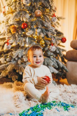 Küçük bir çocuk, 1 yaşında, Noel ağacını süslüyor. Yeni yıl. Noel ağacı.
