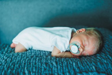 Uyuyan bir bebeğin portresi. Yeni doğmuş bir bebek uyuyor. Beyaz pamuklu bir elbise içinde bir bebek