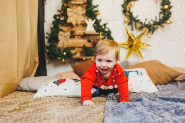 Evdeki Noel süslemelerinin arka planında gülümseyen bir çocuk. Ev Yeni Yıl atmosferi.