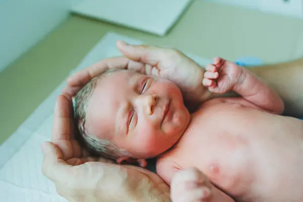 Stock image Newborn baby boy in his father's arms, lying on his arms close-up top view. A man is holding a small child. Healthy Lifestyle. Paternity