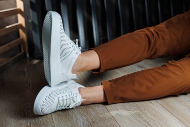 Beyaz delikli deri ayakkabılarla kadın bacaklarının yakın çekimi. Kadın yaz ayakkabıları. Kadın deri ayakkabı koleksiyonu.