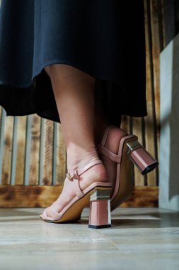 Bej deri sandaletli narin kadın bacakları. Yazlık kadın ayakkabıları koleksiyonu. Yaz için şık kadın ayakkabıları. Kadınların ayaklarında kadın sandaletleri