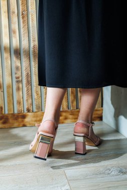 Bej deri sandaletli narin kadın bacakları. Yazlık kadın ayakkabıları koleksiyonu. Yaz için şık kadın ayakkabıları. Kadınların ayaklarında kadın sandaletleri