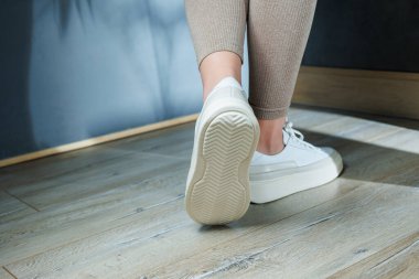 Ayakta beyaz deri kadın klasik spor ayakkabısı. Yaz için şık kadın ayakkabıları. Yaz kadın ayakkabısı koleksiyonu.