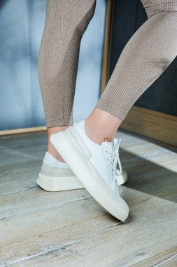 Ayakta beyaz deri kadın klasik spor ayakkabısı. Yaz için şık kadın ayakkabıları. Yaz kadın ayakkabısı koleksiyonu.