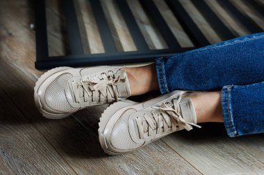 Kadın deri ayakkabı koleksiyonu. Deri bej spor ayakkabılı kadın bacaklar. Şık kadın ayakkabıları..