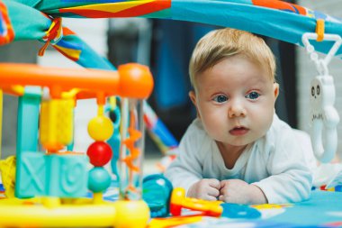 Bir bebek iki ay boyunca gelişim minderinde oynar. Küçük çocuklar için oyuncak halı..