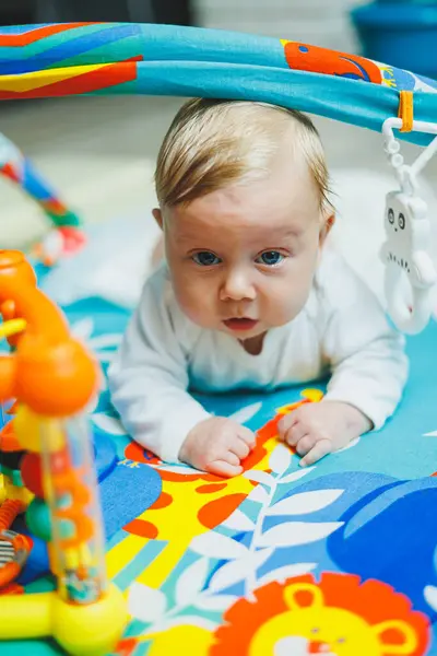 Bir bebek iki ay boyunca gelişim minderinde oynar. Küçük çocuklar için oyuncak halı..