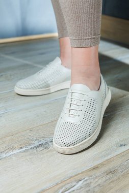 Beyaz spor ayakkabılı kadın bacakları. Rahat kadın yaz ayakkabıları..