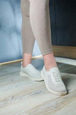 Beyaz spor ayakkabılı kadın bacakları. Rahat kadın yaz ayakkabıları..