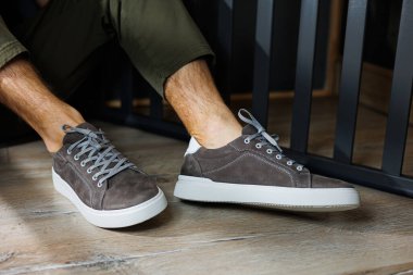 Gri spor ayakkabılı erkek bacakları. Rahat erkek yaz ayakkabıları..