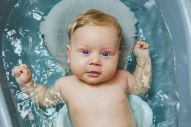 Yeni doğmuş bir bebek banyo yapar. Ebeveynler çocuğu yıkıyor. Yeni doğan banyo yapar. Yeni doğan gülümsüyor. Bebek bakımı