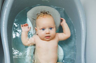 Yeni doğmuş bir bebek banyo yapar. Ebeveynler çocuğu yıkıyor. Yeni doğan banyo yapar. Yeni doğan gülümsüyor. Bebek bakımı