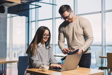 Meslektaşlar, ofiste bilgisayar başında çalışırken tecrübelerini paylaşırlar. Ofis çalışanlarının iş planının tartışılması.