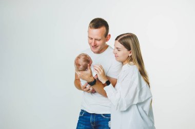 Sevgi dolu anne ve baba kucağında yeni doğmuş bir bebek taşıyor. Baba, anne ve tatlı yeni doğan oğlu. Ebeveynler ve oğulları arasındaki ebeveyn ilişkisi. Mutlu ebeveynlik ve ebeveyn olmanın mutluluğu