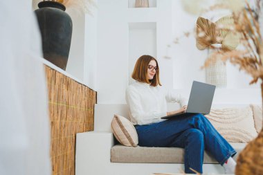 Serbest meslek, iş ve iş. Bir kadın evde dizüstü bilgisayarla uzaktan çalışıyor..