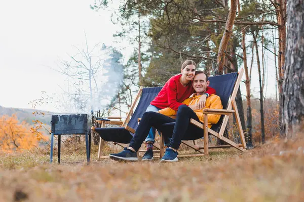 A young couple in love is grilling a barbecue in nature. Family recreation in nature.