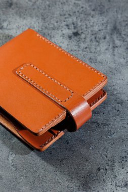 El yapımı hakiki deri ürünler. Erkek ve kadın cüzdanı. Gri bir arka planda yatıyor. Nesnenin üst görünümü.