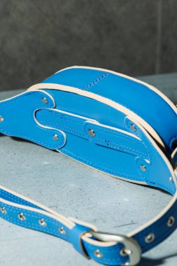 Gri arka planda hakiki deriden yapılmış mavi deri çanta. Deri ürünler.