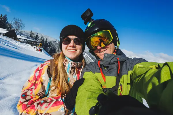 Photo of a couple in love at a snowy ski resort. Winter vacation in the mountains