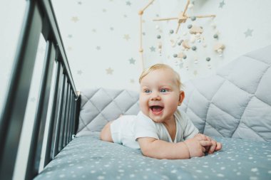 Evde bir beşikte küçük bir çocuk yatıyor. Çocuk parkında yatan beş aylık bir bebeğin portresi. Neşeli mutlu çocuk.
