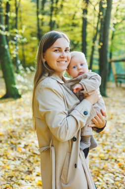 Anne ve küçük çocuk parkın dışındalar. Bir anne oğluna sarılıp onu öper. Mutlu anne ve oğul.