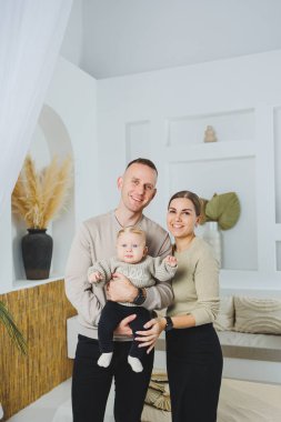 Genç evli çift anne ve baba küçük oğullarına sarılıyor. Çocuklu mutlu bir aile çifti. Evli çift kavramı..