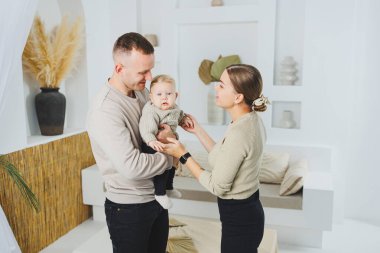Genç evli çift anne ve baba küçük oğullarına sarılıyor. Çocuklu mutlu bir aile çifti. Evli çift kavramı..