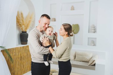 Genç evli çift anne ve baba küçük oğullarına sarılıyor. Çocuklu mutlu bir aile çifti. Evli çift kavramı..