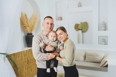 Genç evli çift anne ve baba küçük oğullarına sarılıyor. Çocuklu mutlu bir aile çifti. Evli çift kavramı..