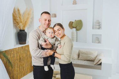 Genç evli çift anne ve baba küçük oğullarına sarılıyor. Çocuklu mutlu bir aile çifti. Evli çift kavramı..