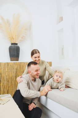 Genç evli çift anne ve baba küçük oğullarına sarılıyor. Çocuklu mutlu bir aile çifti. Evli çift kavramı..