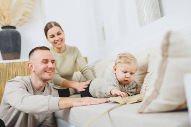 Genç evli çift anne ve baba küçük oğullarına sarılıyor. Çocuklu mutlu bir aile çifti. Evli çift kavramı..