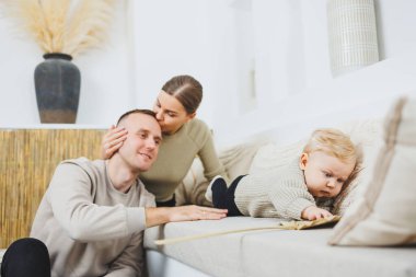 Genç evli çift anne ve baba küçük oğullarına sarılıyor. Çocuklu mutlu bir aile çifti. Evli çift kavramı..