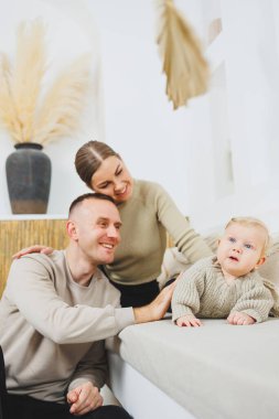 Genç evli çift anne ve baba küçük oğullarına sarılıyor. Çocuklu mutlu bir aile çifti. Evli çift kavramı..