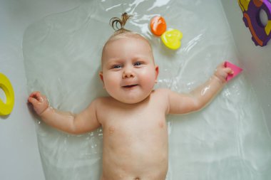 6 aylık bir bebek banyoda banyo yapıyor. - Ne? Bebek cilt bakımı. Çocuk hijyeni.