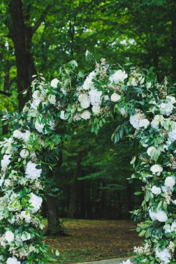 Yeni evlilerin düğünü için kemer. Ormanın arka planında çiçek kemeri.