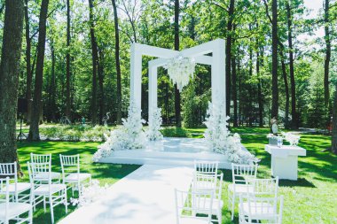 Yeni evlilerin düğünü için kemer. Ormanın arka planında çiçek kemeri.