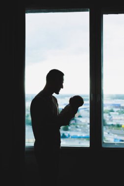 Genç ve sevgi dolu bir baba oğlunu kollarıyla pencerenin arkasına dayar..