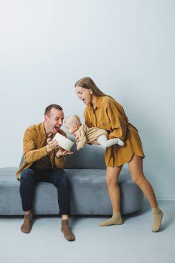 Yeni doğmuş bebeği olan genç ebeveynler, sevgi dolu bir anne küçük oğlunu kollarına alıyor, hassas aile anları, ebeveynlik kavramı. Yüksek kalite fotoğraf