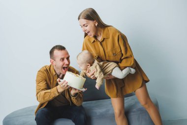 Yeni doğmuş bebeği olan genç ebeveynler, sevgi dolu bir anne küçük oğlunu kollarına alıyor, hassas aile anları, ebeveynlik kavramı. Yüksek kalite fotoğraf