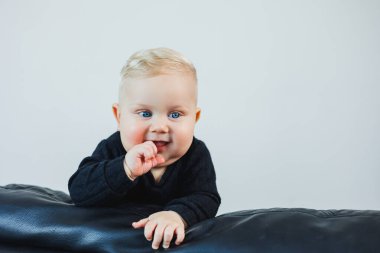 6 aylık şirin Kafkas ve Afrikalı melez bebek öksürüyor. Yüksek sandalyesinde oturuyor ve ilk katı yemeğini yiyor.