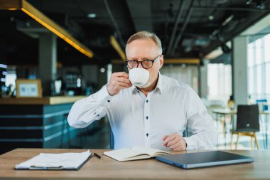 Orta yaşlı yönetmen, olgun yönetmen, ofiste çalışan adam..
