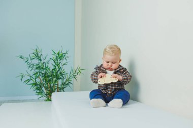 Şık giyinmiş mavi gözlü küçük bir bebek. Gömlekli ve mavi pantolonlu bir çocuk. Çocuk kıyafetleri..