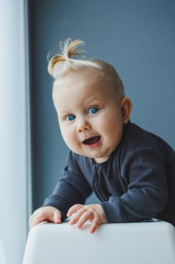 Yüzünde bir gülümseme olan takım elbiseli şirin bir çocuk. Çocuk kameraya bakar, gülümser. Bebekler için kıyafetler.