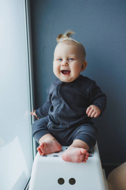 Yüzünde bir gülümseme olan takım elbiseli şirin bir çocuk. Çocuk kameraya bakar, gülümser. Bebekler için kıyafetler.