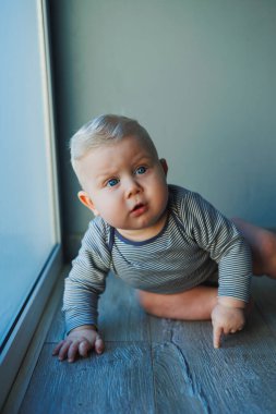 Yüzünde bir gülümseme olan takım elbiseli şirin bir çocuk. Çocuk kameraya bakar, gülümser. Bebekler için kıyafetler.