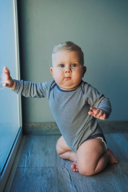 Yüzünde bir gülümseme olan takım elbiseli şirin bir çocuk. Çocuk kameraya bakar, gülümser. Bebekler için kıyafetler.