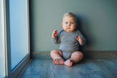 Yüzünde bir gülümseme olan takım elbiseli şirin bir çocuk. Çocuk kameraya bakar, gülümser. Bebekler için kıyafetler.