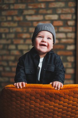 Şapka ve gömlek giymiş bir yaşında küçük bir çocuk. Yüzünde gülümseme olan bir bebek. Bebekler için kıyafetler..